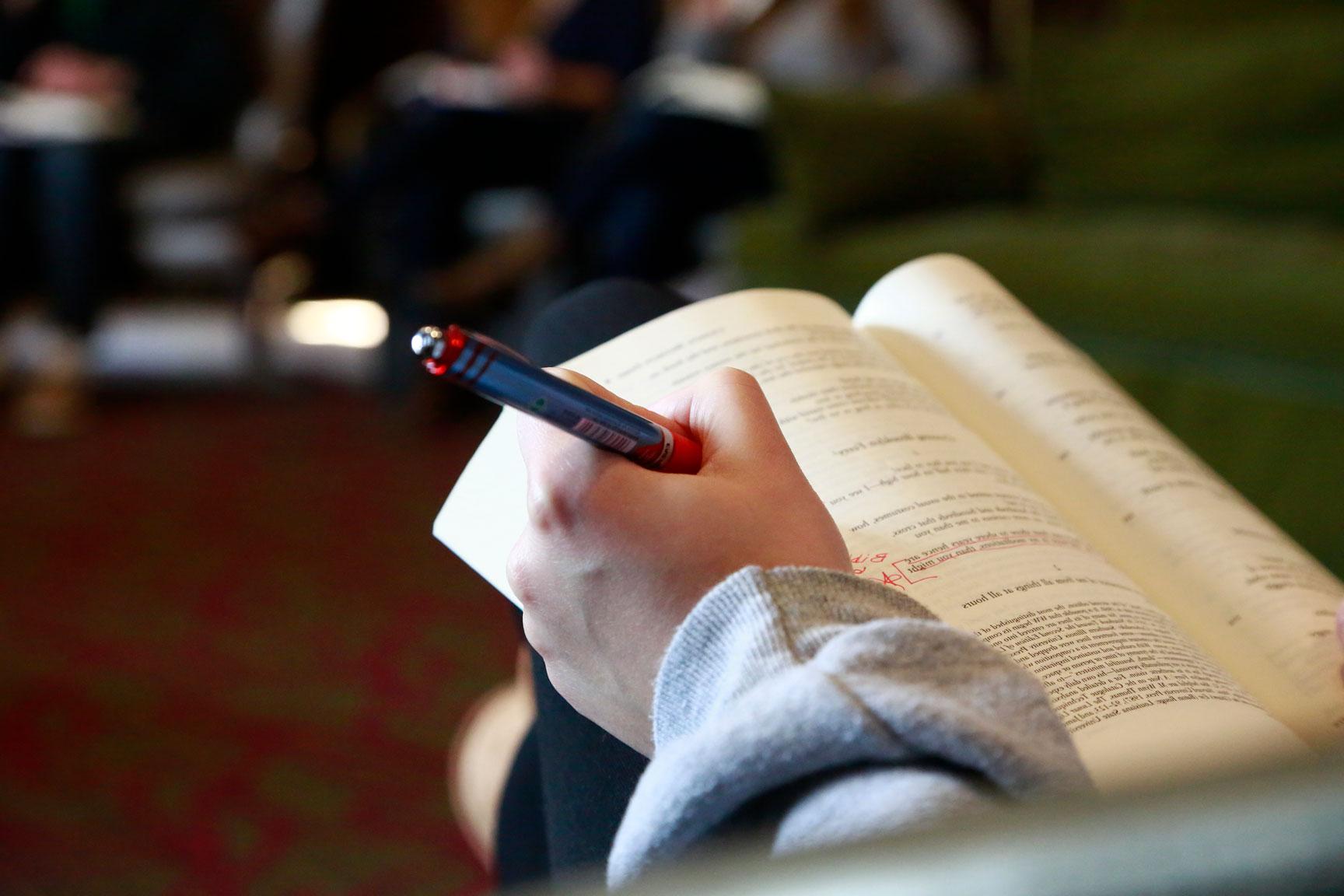 Student makes notations in book during English class